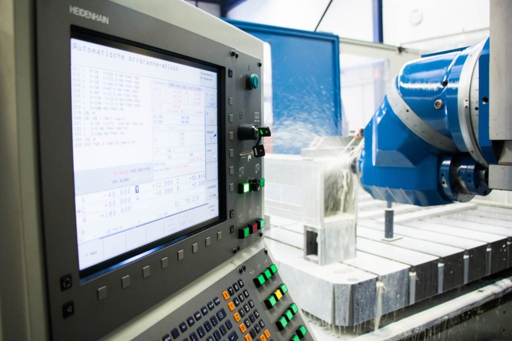 CNC-machine in bedrijf met bedieningspaneel zichtbaar.